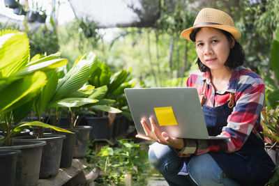 Woman using mobile phone while sitting outdoors