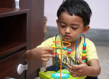 Close-up of boy playing with toys at home