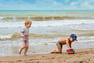 Full length of shirtless boy on beach