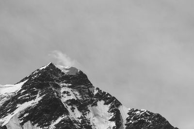 Low angle view of snowcapped mountains against sky