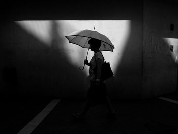 Full length of man holding umbrella