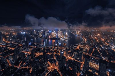 High angle view of illuminated city against sky at night