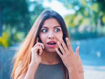 Shocked woman talking on mobile phone