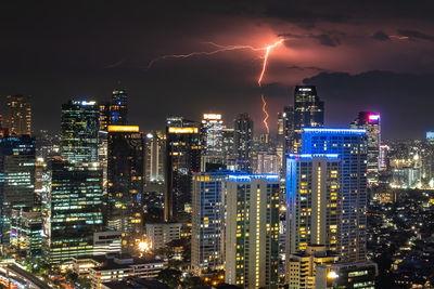 Illuminated cityscape against sky at night