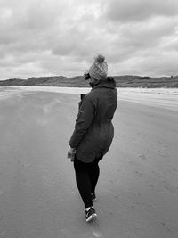 Rear view of woman standing on beach