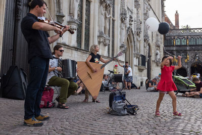 Group of people playing on street in city