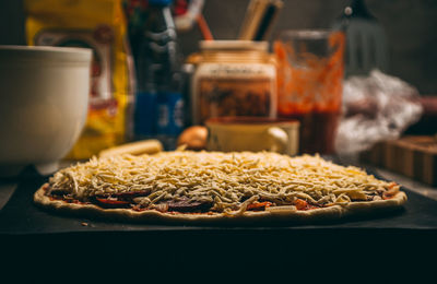 Closeup hand of chef baker in white uniform making pizza at kitchen