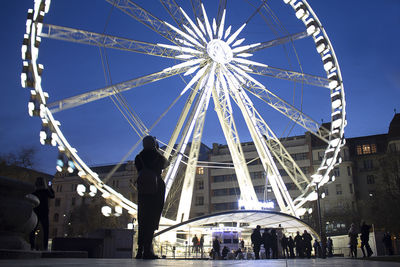 Low angle view of ferris wheel against sky in city