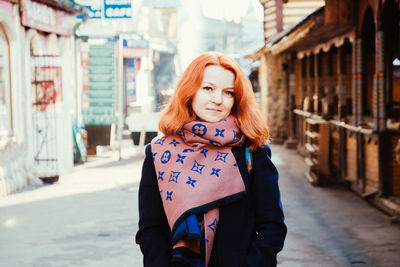 Portrait of smiling woman standing on street in city