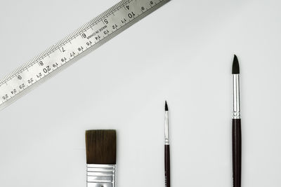 High angle view of paintbrushes on white background