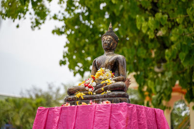 Statue of buddha against trees