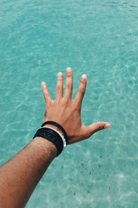 Cropped hand of man over sea