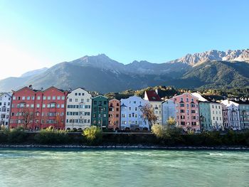 Houses by mountains against clear blue sky