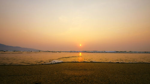 Scenic view of beach against sky during sunset