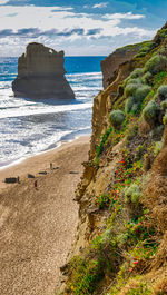Rock formation on beach against sky