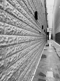 Rear view of person walking on footpath against building