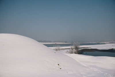 Snow covered landscape against sky