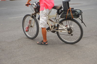 Low section of person riding bicycle on road