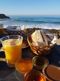 Close-up of breakfast served on table against sea