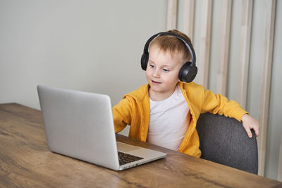 Boy sitting on table at home