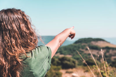 Woman pointing against sky