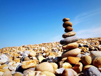 Stack of stones on beach against sky