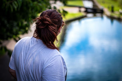 Rear view of woman standing against blue water