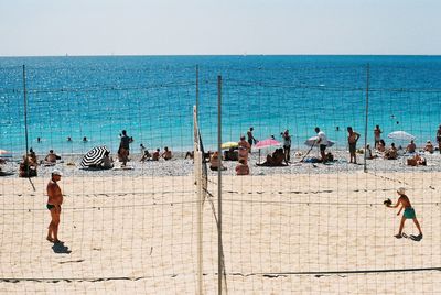 People at beach against sky