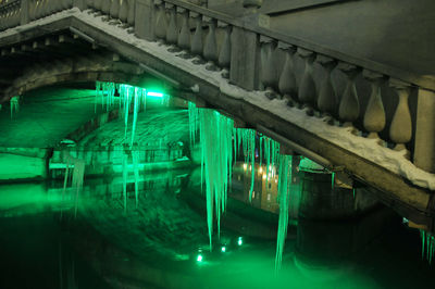 Illuminated bridge over river at night