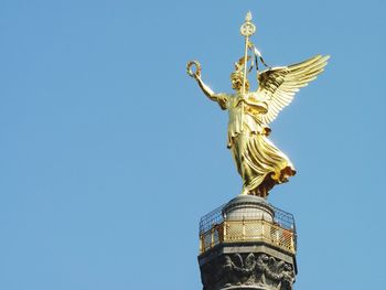 Low angle view of gold statue on berlin victory column against clear sky