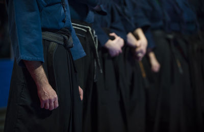 Midsection of karate men standing in studio