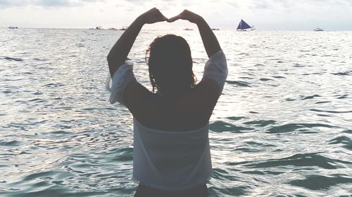 Rear view of woman standing at beach