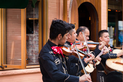 Young man playing guitar at music concert