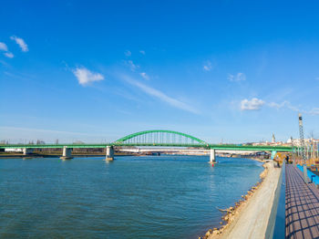 View of bridge over river against blue sky