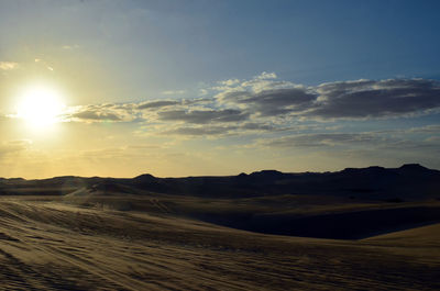 Scenic view of desert against sky during sunset