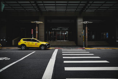 Yellow crossing sign on road in city