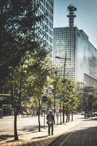 Rear view of people on street amidst buildings in city