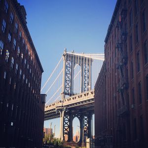 Low angle view of bridge and buildings against sky