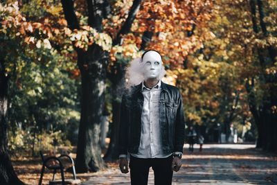 Smoke emitting from mask wear by man while standing outdoors