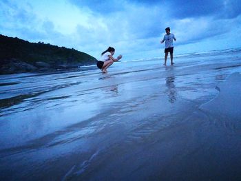 People standing on beach against sky