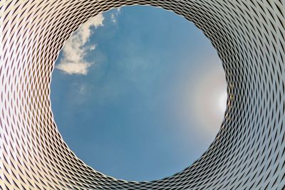 Directly below shot of modern building against sky on sunny day