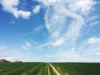 Scenic view of field against cloudy sky