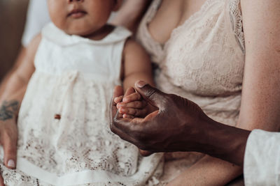 Midsection of mother and baby hand