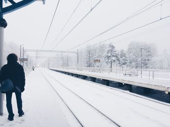 Rear view of man on railroad station during winter