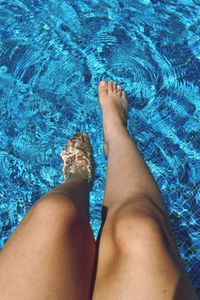 Low section of woman relaxing in swimming pool