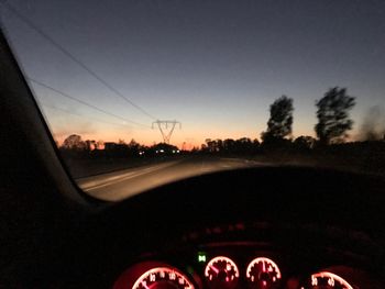 Cars on road against sky during sunset