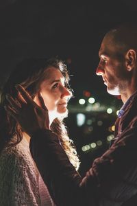 Side view of couple kissing at night