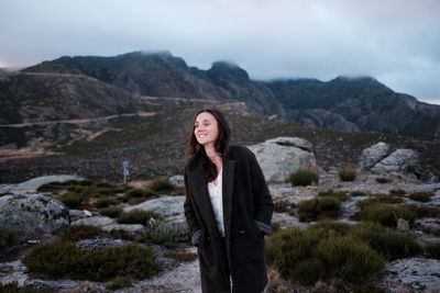 Portrait of young woman standing on mountain