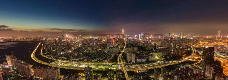 High angle view of illuminated city buildings against sky at night