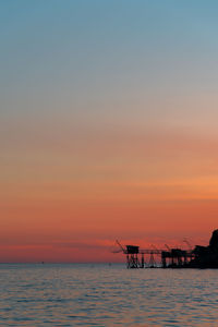 Scenic view of sea against sky during sunset. scenic view of fishery against sea during sunset 